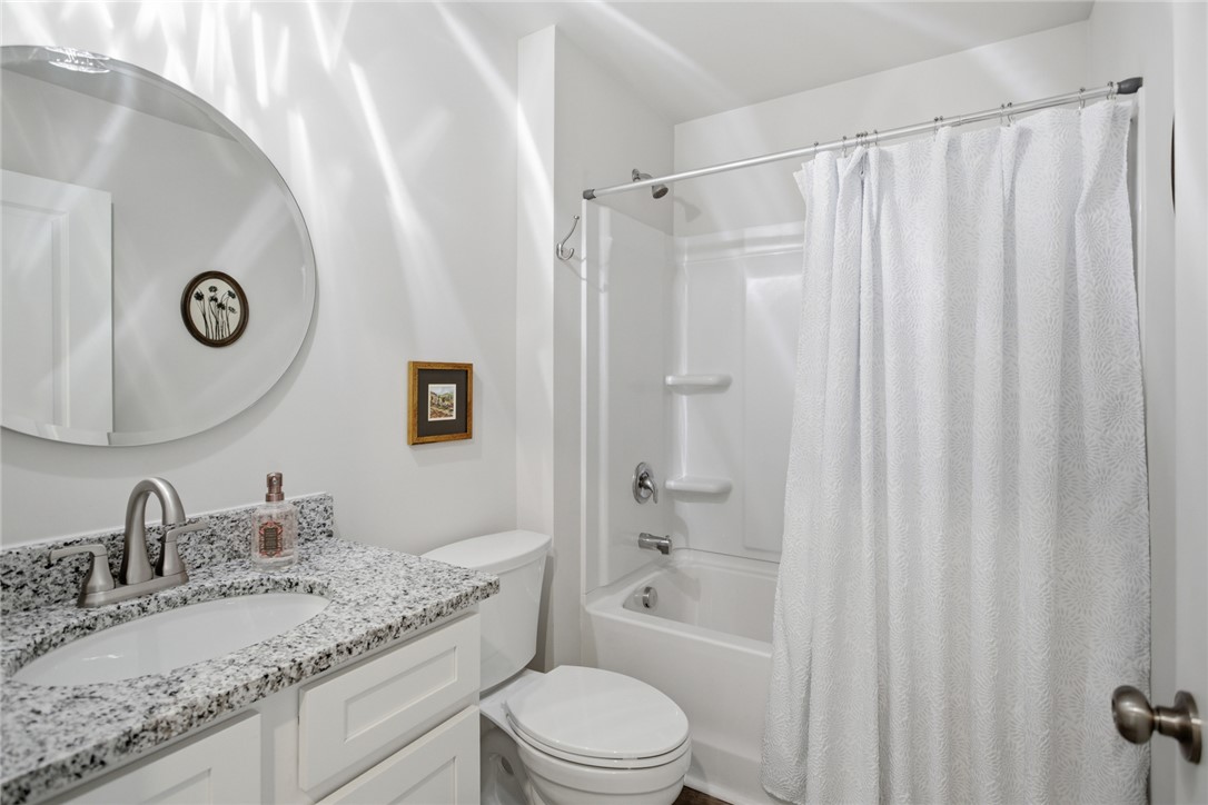 412 Chadwick Lane Walhalla, SC 29691 - Photo 18 of 37 This functional bathroom features a tub-shower combination, a vanity with ample counter space, and a large circular mirror.