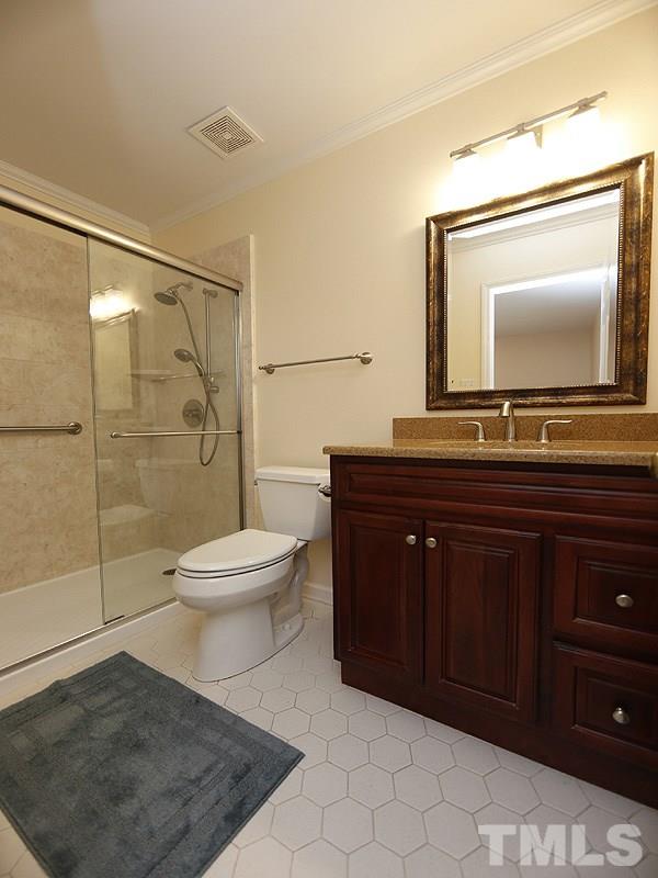 6400 Meadow View Drive Raleigh, NC 27609 - Photo 11 of 17 a bathroom with a toilet a sink and glass door