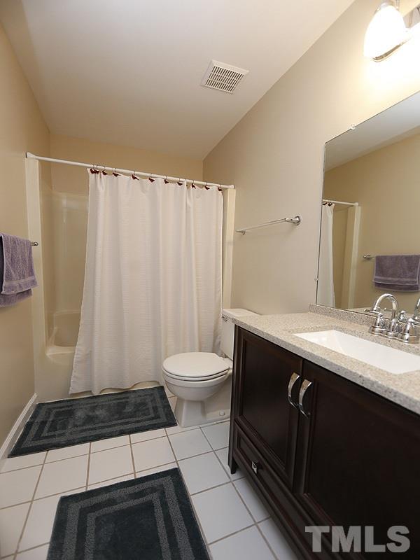 6400 Meadow View Drive Raleigh, NC 27609 - Photo 13 of 17 a bathroom with a sink a toilet a mirror and shower curtain