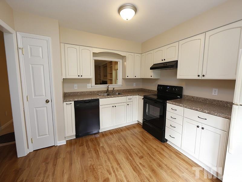 6400 Meadow View Drive Raleigh, NC 27609 - Photo 4 of 17 a kitchen with stainless steel appliances a white stove top oven and white cabinets
