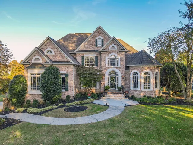 a front view of a house with a yard and potted plants