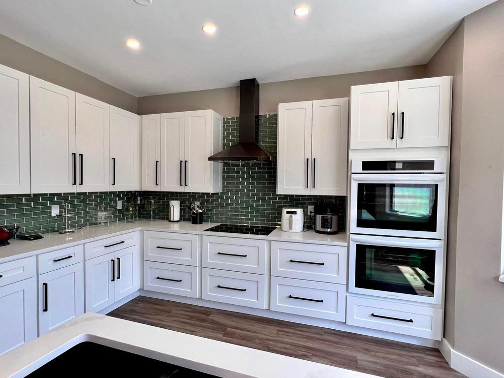 a kitchen with stainless steel appliances kitchen island granite countertop white cabinets and sink
