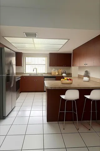 a kitchen with stainless steel appliances a stove a sink and a refrigerator