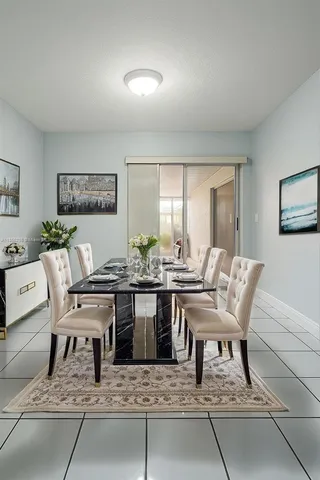 a living room with furniture a rug and wall paintings