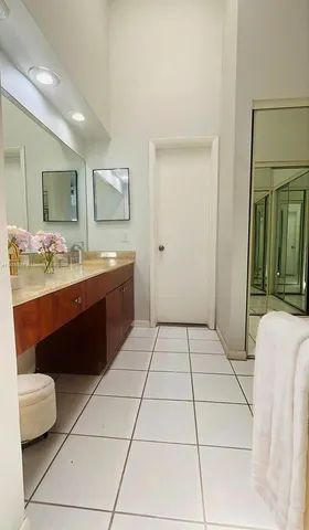 a spacious bathroom with a vanity sink and a mirror