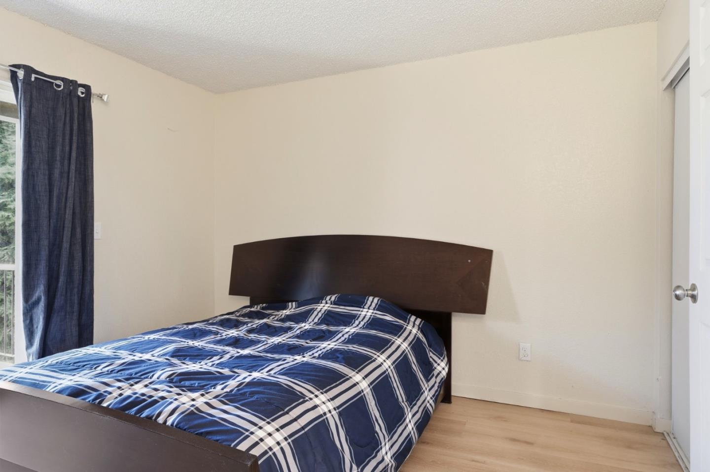 7283 Florin Road, Unit 8 Sacramento, CA 95828 - Photo 21 of 35 a bedroom with a bed and wooden floor