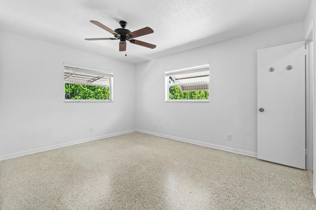 751 Hummingbird Way, Unit 7 North Palm Beach, FL 33408 - Photo 13 of 40 an empty room with window and ceiling fan