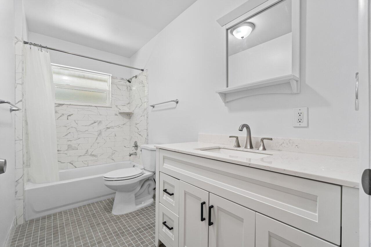 751 Hummingbird Way, Unit 7 North Palm Beach, FL 33408 - Photo 15 of 40 a bathroom with a sink a toilet and shower