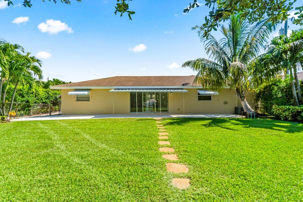 751 Hummingbird Way, Unit 7 North Palm Beach, FL 33408 - Photo 2 of 40 a view of a house with a yard