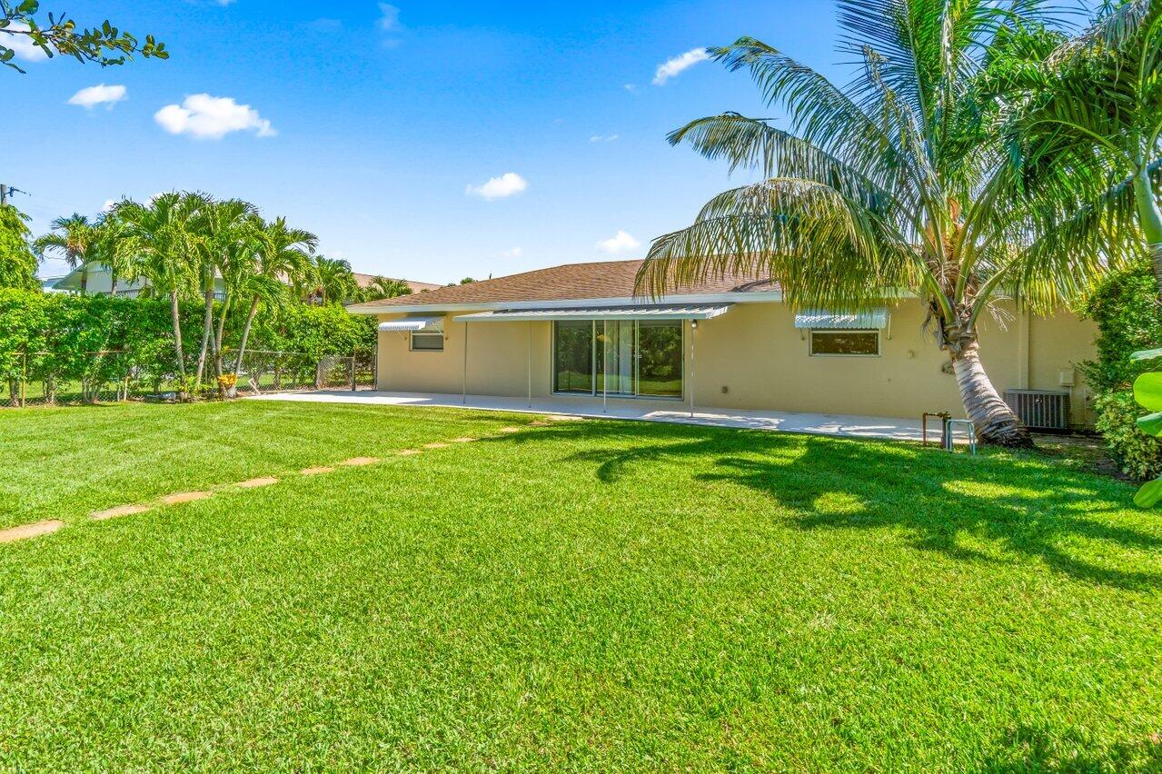 751 Hummingbird Way, Unit 7 North Palm Beach, FL 33408 - Photo 30 of 40 a front view of house with yard and outdoor seating