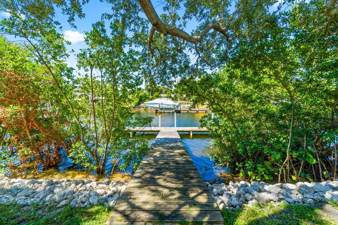 751 Hummingbird Way, Unit 7 North Palm Beach, FL 33408 - Photo 32 of 40 a view of a yard with plants and large trees