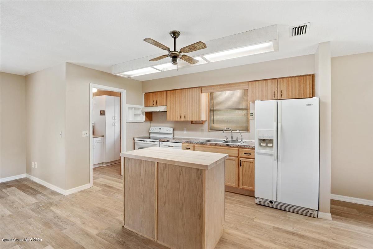 3600 Leghorn Road Grant Valkaria, FL 32950 - Photo 11 of 33 a kitchen with a refrigerator a sink and dishwasher with wooden floor