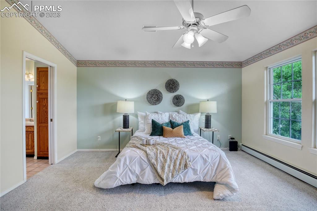 12595 Mc Cune Road Black Forest, CO 80106 - Photo 4 of 44 a bedroom with a large bed and a chandelier