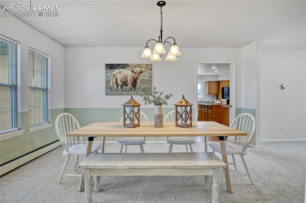 12595 Mc Cune Road Black Forest, CO 80106 - Photo 44 of 44 a view of a dining room with furniture wooden floor and chandelier