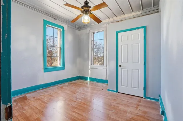 a view of an empty room with wooden floor and a cabinet