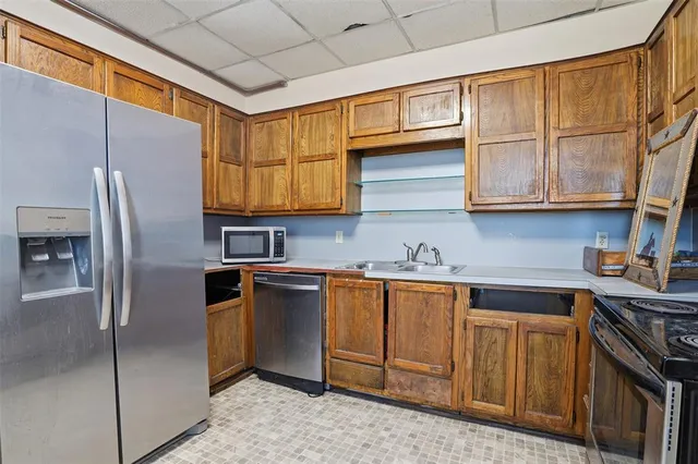 a kitchen with granite countertop cabinets stainless steel appliances and a window
