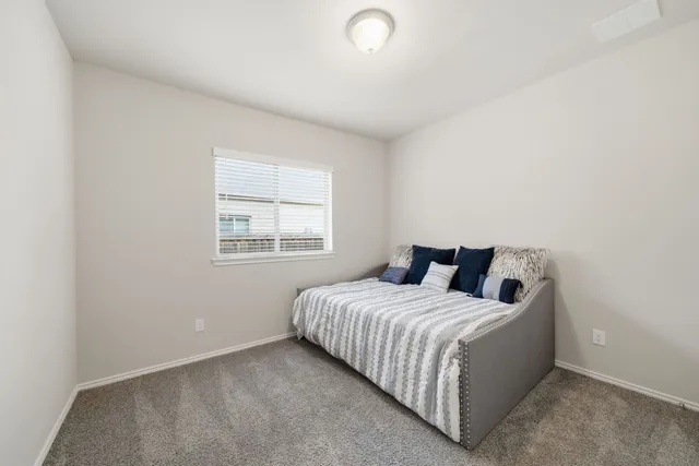 a large bed sitting in a bedroom next to a window