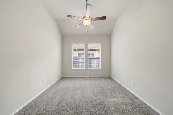 a view of a room with a ceiling fan and window