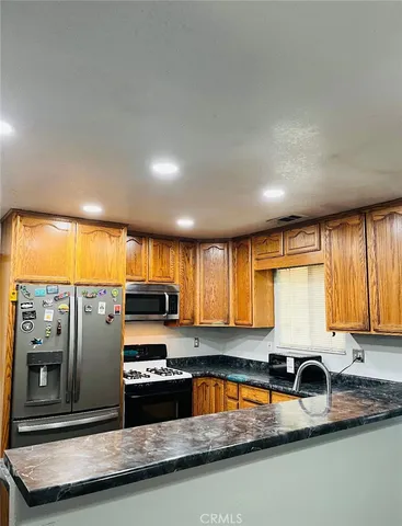 a kitchen with stainless steel appliances granite countertop a sink a stove and cabinets