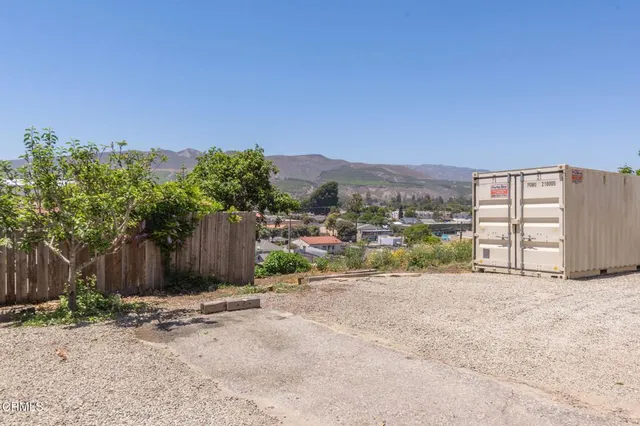 a view of a dry yard with wooden fence