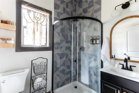 a bathroom with a sink a toilet and shower