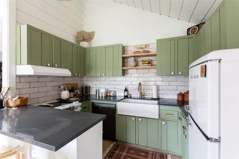 a kitchen with a sink a refrigerator and cabinets