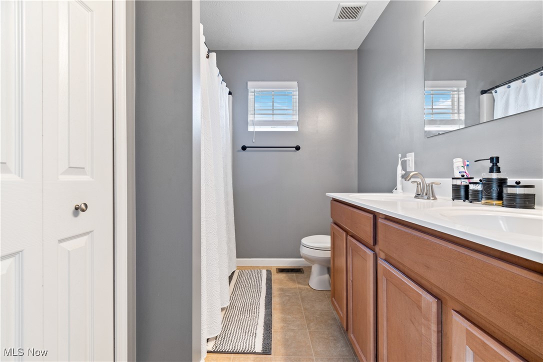 4467 Ridgestone Way Medina, OH 44256 - Photo 17 of 31 Bathroom with double vanity, toilet, and tile patterned flooring
