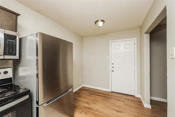 a view of a kitchen with wooden floor and electronic appliances