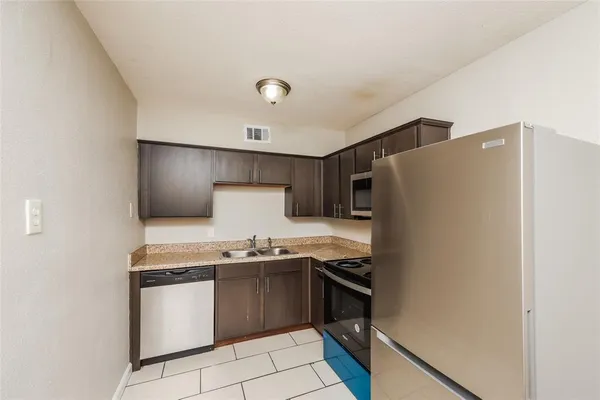 a kitchen with stainless steel appliances a refrigerator sink and stove