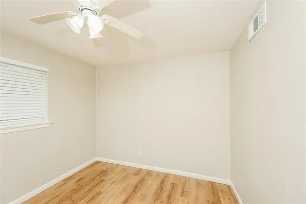 a view of a small space with wooden floor and a window