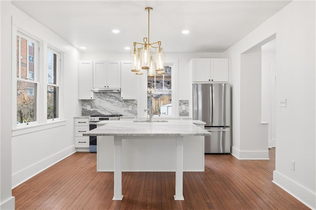 511 East 2nd Avenue Tarentum, PA 15084 - Photo 11 of 41 a kitchen with kitchen island stainless steel appliances a dining table chairs and wooden floor