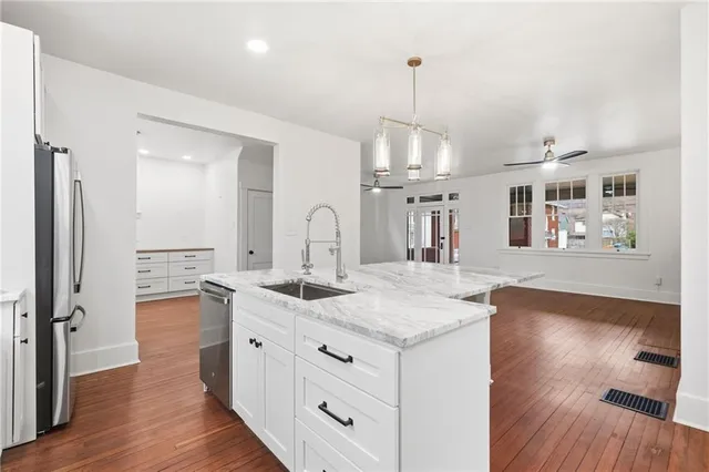 a kitchen with a sink chandelier and wooden floor