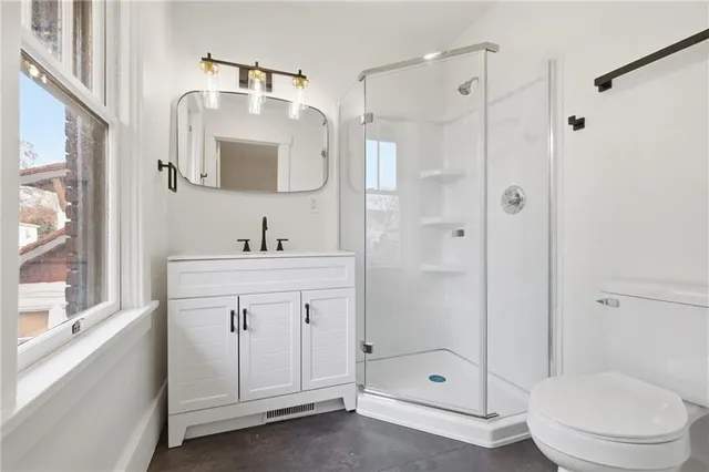 a bathroom with a sink a toilet and shower