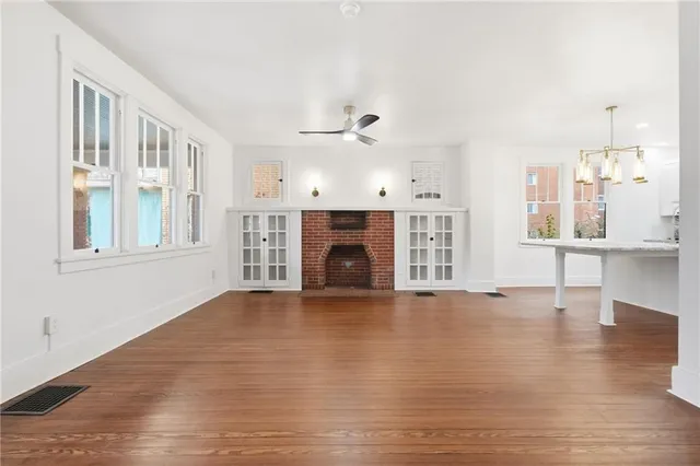 a view of an empty room with a fireplace and a window