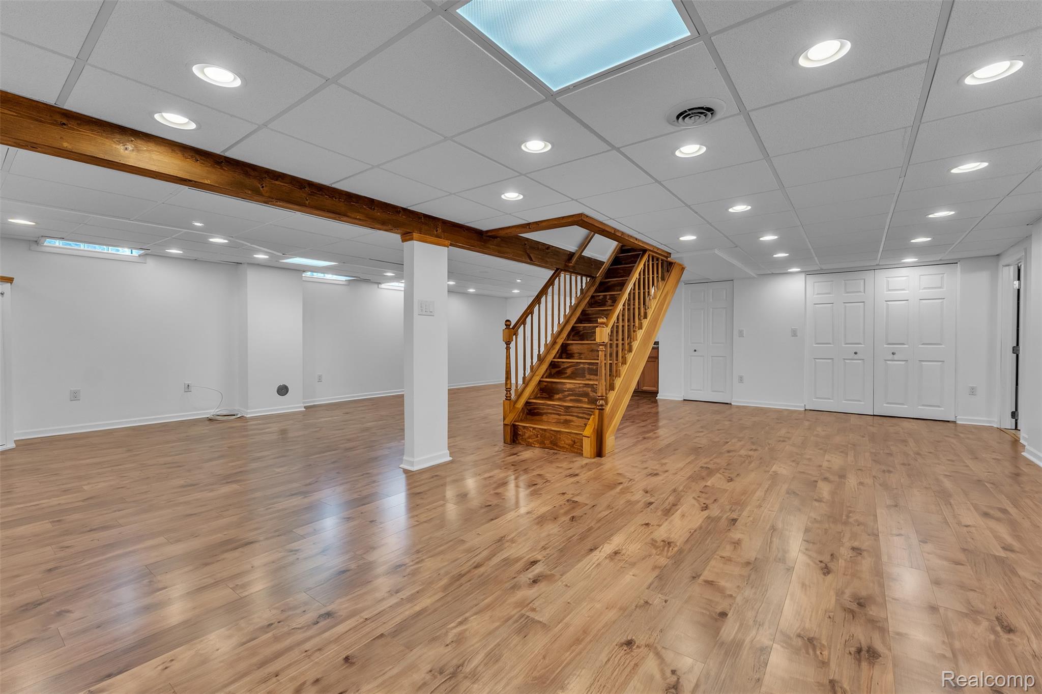 7000 Woonsocket Street Canton, MI 48187 - Photo 50 of 65 Spacious lower level featuring wood-finish flooring, a full staircase with wood railing, recessed lighting, and a drop ceiling with integrated light panel