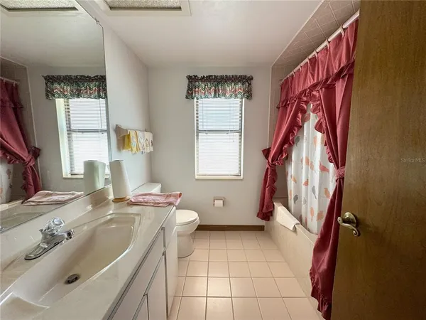 a bathroom with a sink a toilet and a window