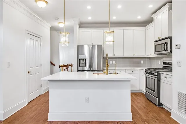 a kitchen with stainless steel appliances kitchen island a sink and a stove