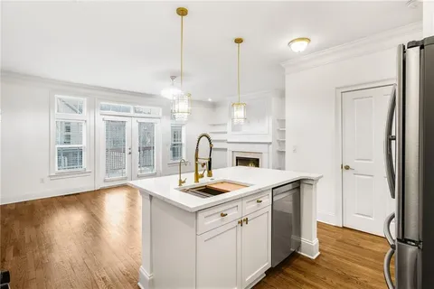 a open kitchen with a sink a stove and wooden floor