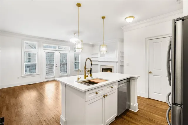 a open kitchen with a sink a stove and wooden floor