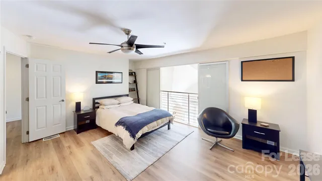 a bedroom with a bed cupboard mirror and a window