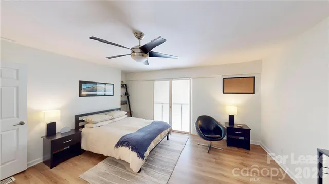 a spacious bedroom with a bed and a large window