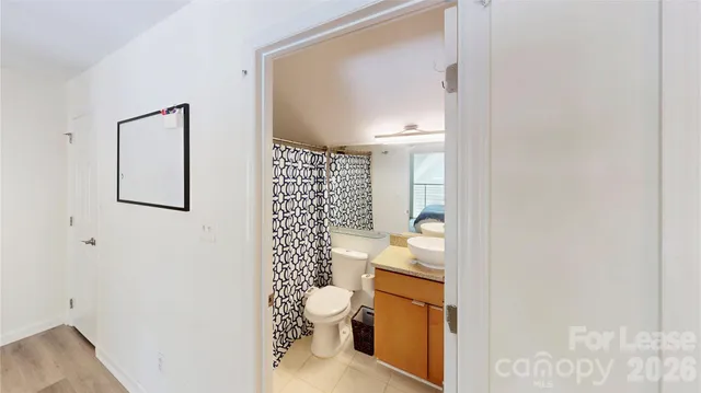 a bathroom with a granite countertop toilet and a shower
