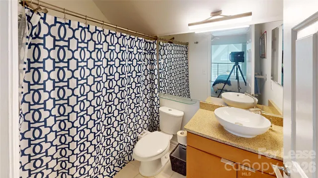 a bathroom with a granite countertop toilet and a sink