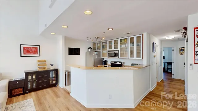 a large kitchen with stainless steel appliances granite countertop a refrigerator and a stove top oven