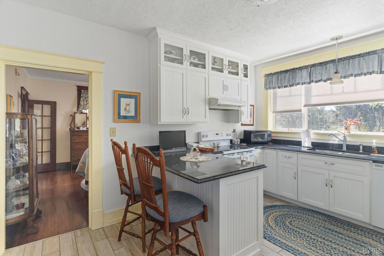 1876 Dickie Road Roseland, VA 22967 - Photo 24 of 75 a kitchen with stainless steel appliances granite countertop a table chairs sink and cabinets