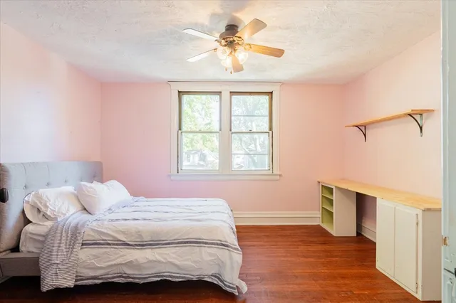 a bedroom with a bed and a chandelier fan