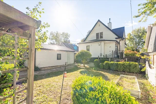 a view of a yard with plants and trees