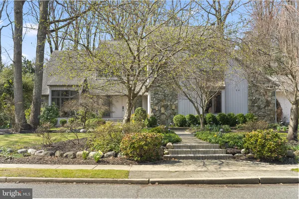 a front view of a house with plants and trees