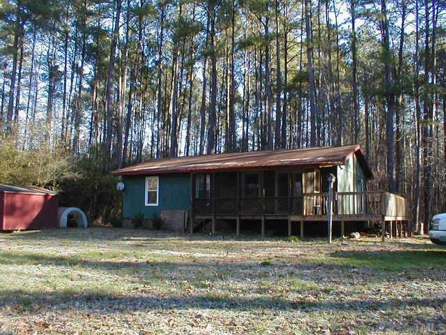 263 Pea Ridge Road New Hill, NC 27562 - Photo 2 of 7 a view of a house with a yard and large tree