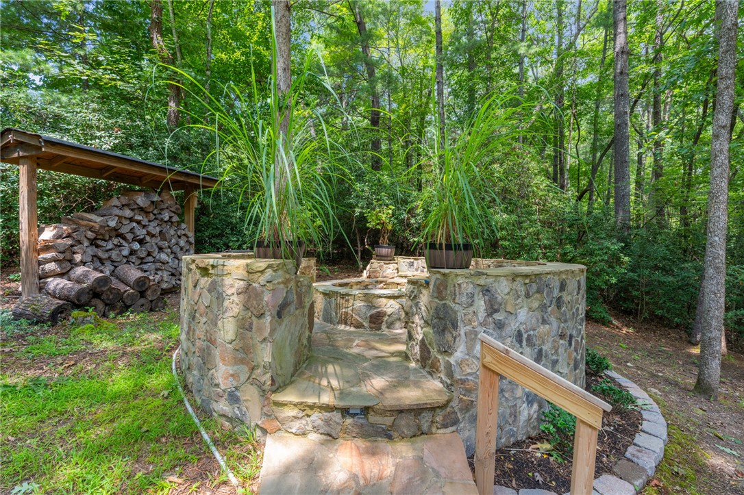 300 Whispering Falls Road Pickens, SC 29671 - Photo 29 of 41 Natural stone steps lead to an outdoor fire pit area surrounded by mature trees.